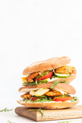 Pita with arugula, avocado, cucumber, tomatoes, chicken and egg. Sandwich with chicken, egg and vegetables. Light concrete background. Copy space.