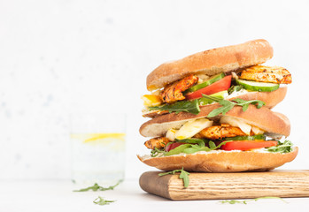 Pita with arugula, avocado, cucumber, tomatoes, chicken and egg. Sandwich with chicken, egg and vegetables. Light concrete background. Copy space.