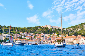 Fototapeta na wymiar Luxury yachts, ships and fishing boats moored in harbor Hvar, Croatia