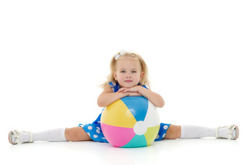 Little girl is playing with a ball