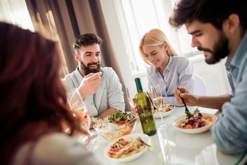 Group of friends enjoying meal at home together