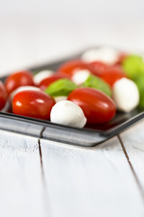 Dish with fresh caprese salad isolated on white