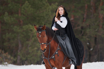 Beautiful girl in historical clothes riding a horse