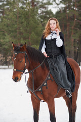 Fototapeta premium Beautiful girl in historical clothes riding a horse
