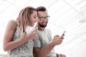 Laughing couple watching photos on smartphone