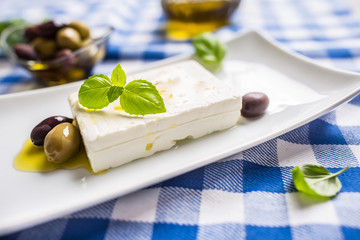 Greek cheese feta with olive oil olives and basil leaves