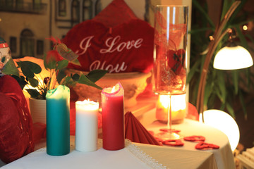 Serce i płonące świece na stole w restauracji.