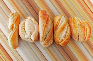 Five different small breads on the brown linear background