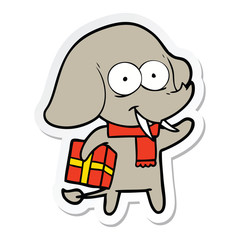 sticker of a happy cartoon elephant with present