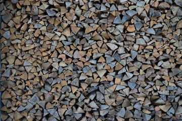 Background of dry chopped firewood logs in a pile
