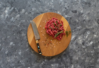 Fresh meat cut into thin strips on cutting board. 