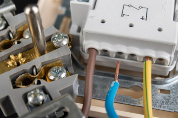 Electrical wires mounted to an electrical outlet. Electrical accessories installed in the house.