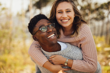 Interracial couple having fun outdoors - Powered by Adobe