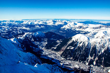 Panoramic view of mountains and french town called Chamonix-Mont-Blanc. All around the summits of Alps covered with snow.  Ideal destination for winter holiday full of skiing and snowboarding.