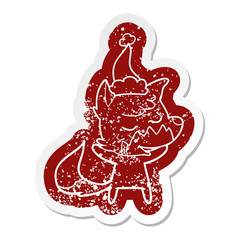 friendly cartoon distressed sticker of a fox wearing santa hat