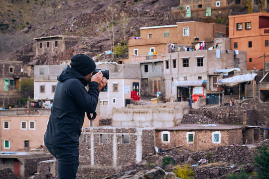 Journalist photograper capturing picture of a typical moroccan remote town in the Atlas mountains Africa