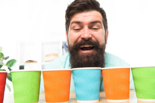 Alternative concept. Pick one. Diversity and recycling. Eco paper cup. Coffee to go paper cup. How many cups per day. Choose from alternatives. Man bearded choosing one of lot colorful paper cups