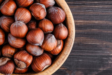 Filtered image of Hazelnuts in a wooden bowl on rustic background,top view.