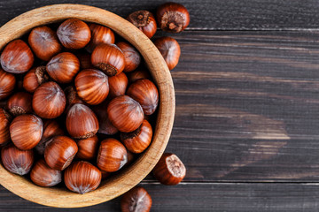 Filtered image of Hazelnuts in a wooden bowl on rustic background,top view.