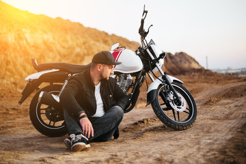 Obraz premium Smiling happy biker in sitting on motorcycle on road
