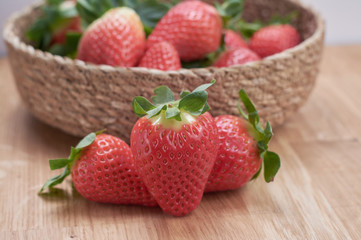 close up fresh strawberries with natural wood background in a basket