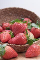 close up fresh strawberries with natural wood background in a basket