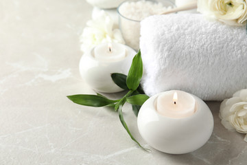 Fototapeta na wymiar Beautiful spa composition with candles and flowers on marble background, space for text