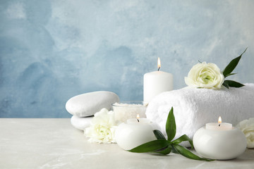 Beautiful spa composition with candles and flowers on table, space for text