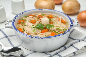 Dish with fresh homemade chicken soup served on table