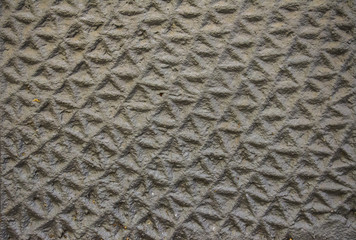 Background - concrete wall with a decorative rough texture of the rows of triangles