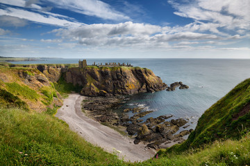 Pebble beach at Old Hall Bay North Sea from clifftop south of Donnottar Castle Medieval fortress ruins near Stonehaven Scotland UK