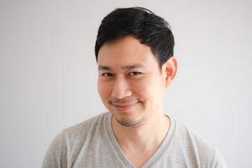 Funny tricky awkward smirk face of man in grey t-shirt.