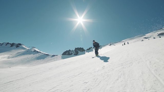 EXTREME ACTION Skier hits huge jump and throws cool trick. Blonde skier races into jump extreme trick in sunny mountains action. Big mountain groomed terrain park at California ski resort