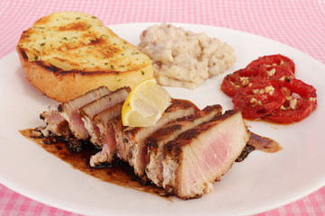 Ahi Tuna Steak balzamic vinegar sauce and served with fresh grilled tomatoes and potatoes.