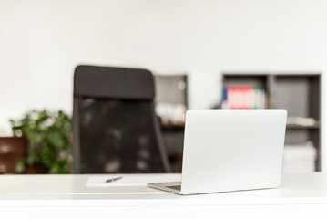 Business concept - work in a bright modern office with a laptop and a notebook on the desk