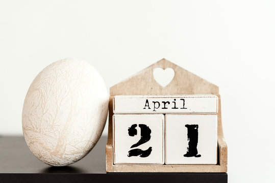 April 21 with an easter egg and a calendar on a desk near white wall
