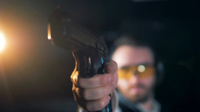 A hand holding a gun, close up.