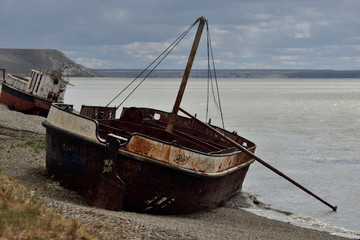 viejos barcos oxidados encallados en la costa durante la marea alta