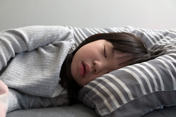 Asian child girl sleeping on the bed in her bedroom