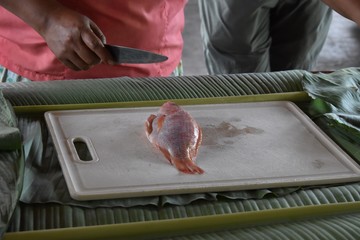 Woman cooking red snapper fish