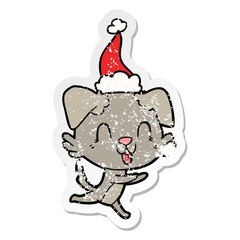 laughing distressed sticker cartoon of a dog wearing santa hat