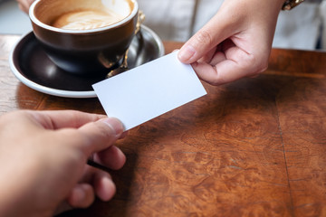 Obraz premium A woman holding and giving empty business card to someone