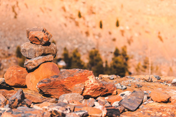 Pyramid of stones on mountainside on sunny day