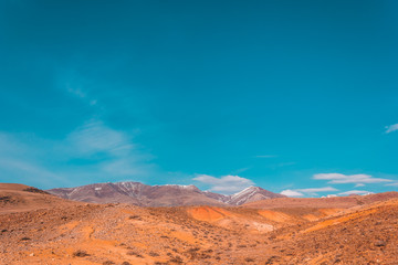Naklejka premium Yellow and red rocks under blue sky. Desert landscape with mountains.