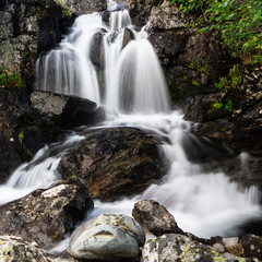 Vertical waterfall in rocks. Mountain river in mountains.