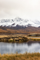 Autumn panorama. View of mountains and lake. Mountain range on horizon. Travel to mountain valley with rivers.