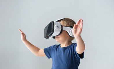 Portrait of happy boy in a virtual reality headset. Attractive kid using vr goggles at home. Entertainment technology and generation Z concept.