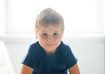 Portrait of hysterical boy. Upset caucasian kid crying at home.