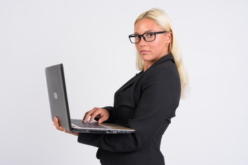 Young blonde businesswoman holding laptop and looking at camera