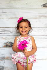 Tender smiling toddler, with a flower in her hand